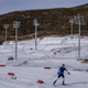 An athlete from Team France passes snowless hills as he takes part in a training session Zhangjiakou National Biathlon Centre on February 7, 2022 in Zhangjiakou, China. The Beijing 2022 Winter Olympics are held entirely on artificial snow.